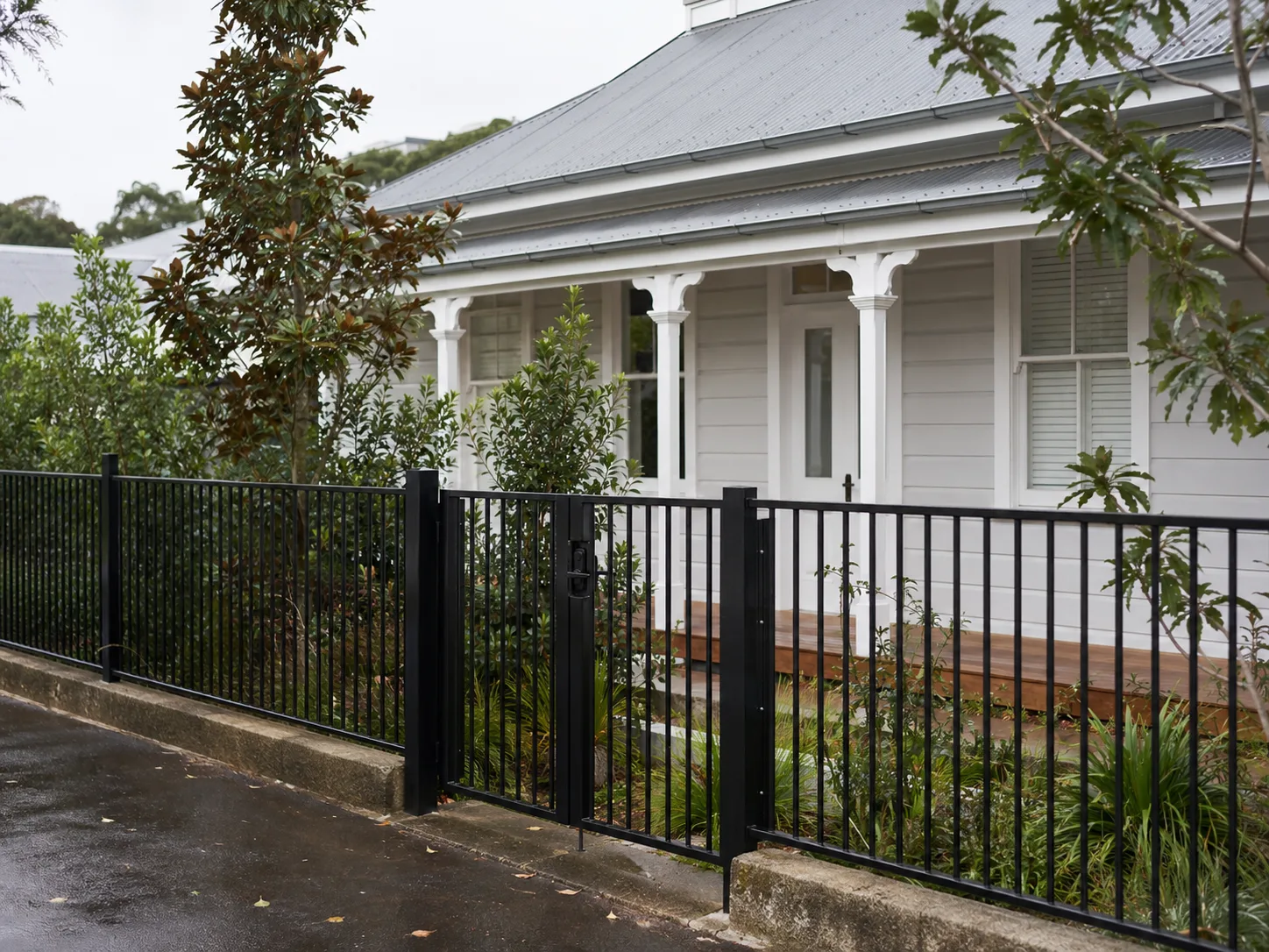 Black aluminium front fence and gate outside a white villa
