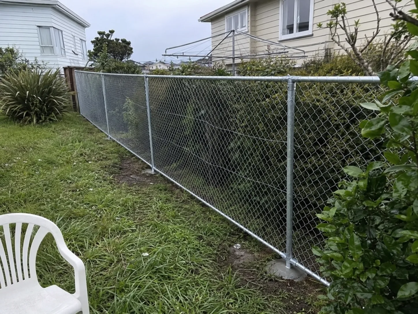Galvanised chain-link fence enclosing a residential garden